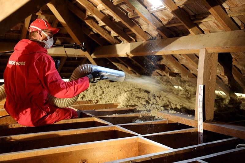 Projection de la laine de roche Rockwool dans des combles